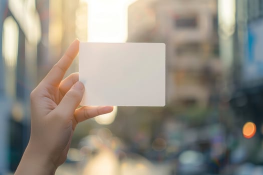 Blank Business card, Paper card template in hand grab on blur outdoor city background. photo