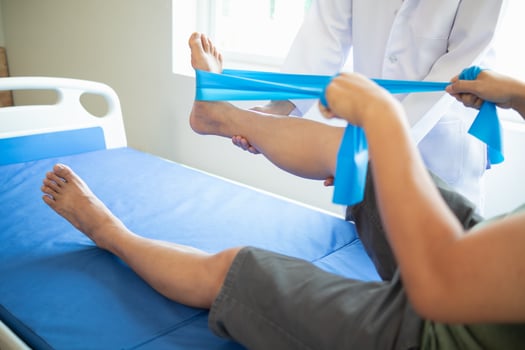 female doctor using elastic bands help patient regain muscle movement after recuperating from muscle injury and wants rehabilitate her be able use her normal daily life by practicing physical therapy photo