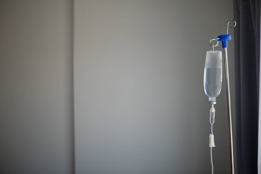 Bottles saline are hung on poles for giving saline patients and passing them through an intravenous line on patient bed. Medical which doctor gives saline solution patient through an intravenous photo