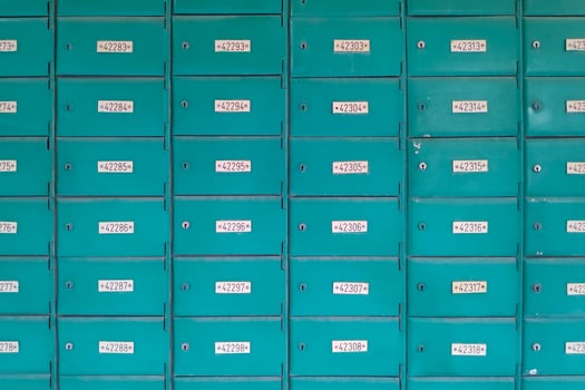 A wall of mail boxes outside a post office photo