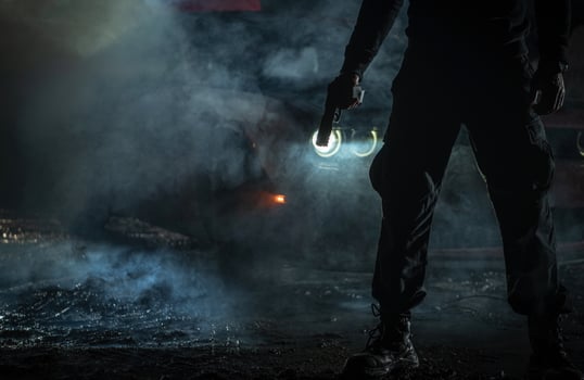 Silhouette of a Person Holding a Gun in Smoky Nighttime Setting photo