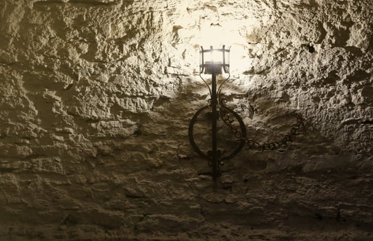 Lighted medieval castle torch hanging on a stone wall, vintage objects photo