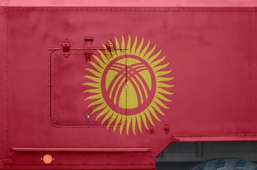 Kyrgyzstan flag depicted on side part of military armored truck closeup. Army forces conceptual background photo