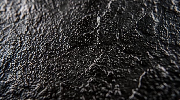 A macro shot of matte black metal displaying a bumpy speckled texture with a matte nonreflective quality photo