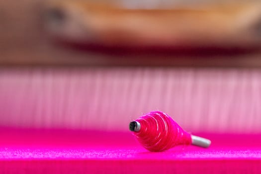 Pink Thread Spool on Fabric photo