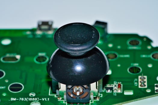 a black joystick on a green circuit board photo