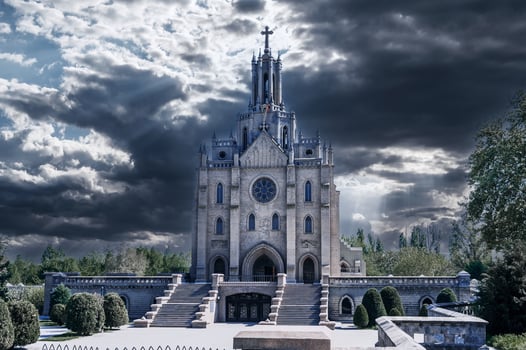 Cathedral of the Sacred Heart of Jesus on background of dark dramatic cloudy sky. Ancient polish Roman Catholic Church in gothic style in Tashkent in Uzbekistan photo