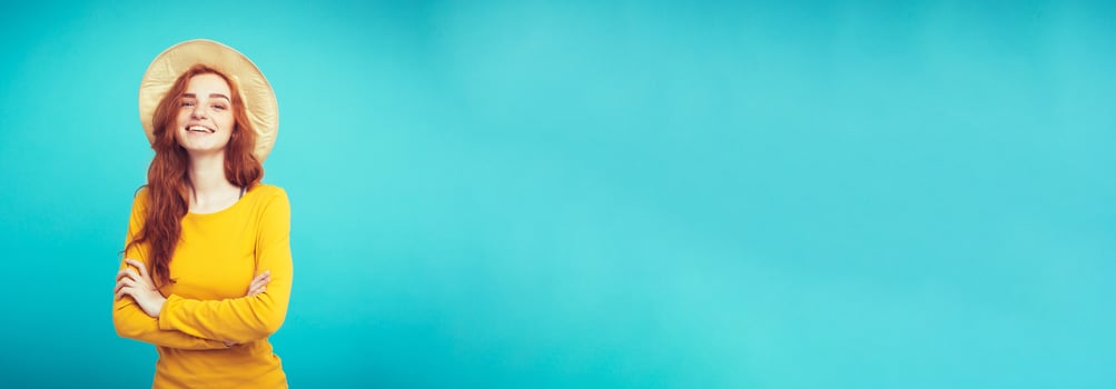Travel concept - Close up Portrait young beautiful attractive redhair girl wtih trendy hat and sunglass smiling. Blue Pastel Background. Copy space photo