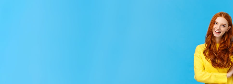 Cheerful, charismatic friendly redhead female showing high five, number fifth as making order, reservation or booking place for party, counting, standing blue background carefree in yellow sweater photo