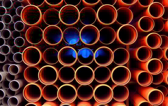 Plastic orange pipes stacked detailed photo
