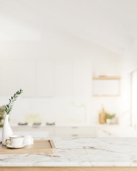 A space for displaying products on a white marble kitchen countertop in a minimalist white kitchen. photo