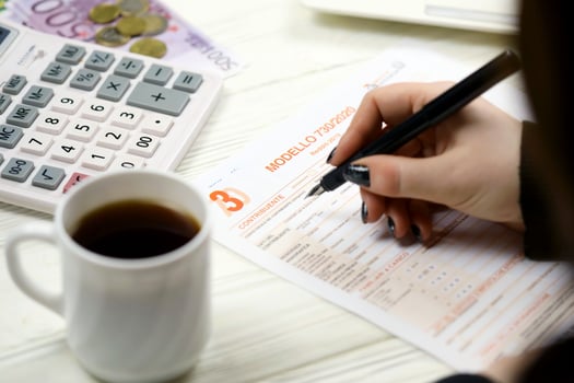 KYIV, UKRAINE - OCTOBER 31, 2023 Accountant fill italian tax form Modello 730 individual income tax return in end of tax period. Taxation and paperwork routine photo