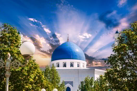 blue dome of modern white marble Islamic Masjid Minor Mosque in Tashkent in Uzbekistan on background of the sunset sky in summer photo