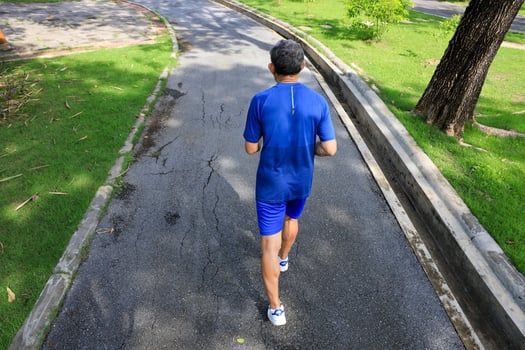 Senior Asian man is doing running exercise work out in the morning at public park for healthy and longevity concept photo