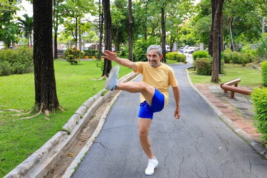 Senior Asian man is stretching his leg muscle during warm up exercise work out in the morning at public park for healthy and longevity concept photo