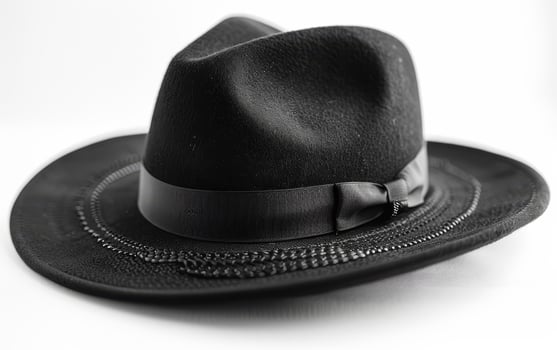 Black fedora hat or felt hat with black ribbon and white background photo