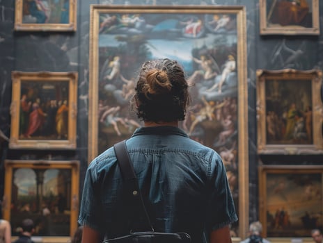 Back of an adult person looking at renaissance style paintings in an old museum art gallery photo