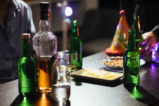 In the background, many bottles of alcohol were placed on the table at the party. Bottles of alcohol were given out to friends and group members to drink together in celebration of business success. photo