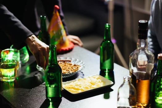 In the background, many bottles of alcohol were placed on the table at the party. Bottles of alcohol were given out to friends and group members to drink together in celebration of business success. photo