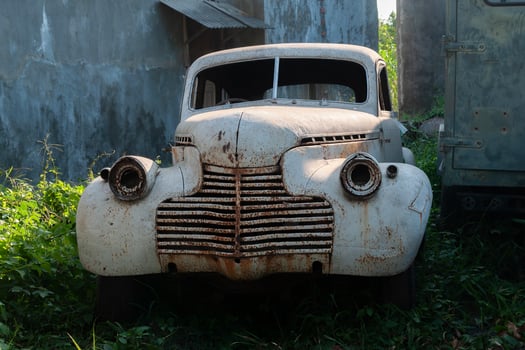 an old abandoned and damaged car parked in the backyard photo