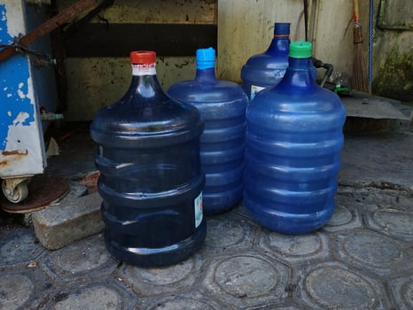 Gallons of used water on the paving floor. pile of gallons of drinking water photo