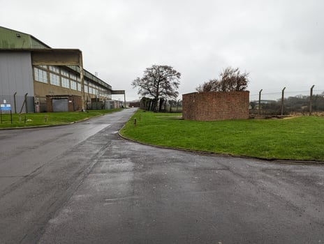 Brick structures beside a wet road near a warehouse photo
