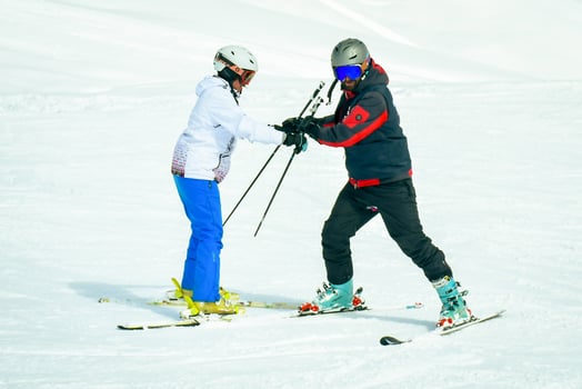 Gudauri, Georgia - 24th january, 2022 - Caucasian male ski instructor teaching to ski beginner woman skier in Gudauri ski resort. Ski holiday in Georgia photo
