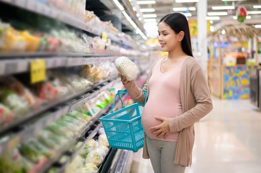 Beautiful pregnant woman shopping healthy food at grocery shop photo