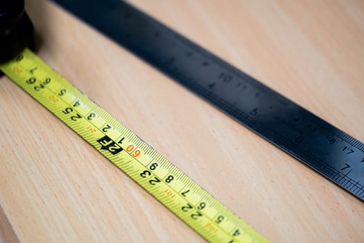 Tape measure and metal ruler on wooden desk photo