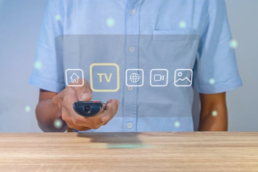 A man using a smart TV remote to change and control the entertainment menu photo