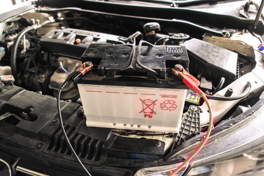 Car battery recharge with a battery charger in an engine compartment , Car battery maintenance concept photo