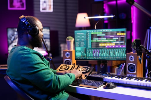 Skilled audio technician mixing and mastering tunes on console, adding sound effects in post production. Songwriter producing new tracks for his album, working in home studio with gear. photo