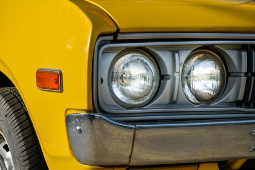 Front of classic retro car yellow,car tires and circle headlight car, headlight of a car,front light details yellow car,charm of classic retro cars. photo