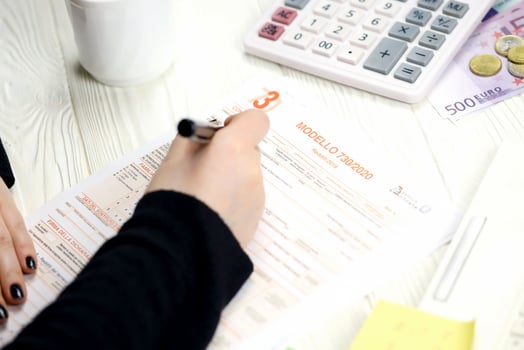 KYIV, UKRAINE - OCTOBER 31, 2023 Accountant fill italian tax form Modello 730 individual income tax return in end of tax period. Taxation and paperwork routine photo