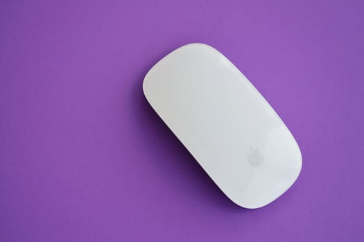 KYIV, UKRAINE - NOVEMBER 27, 2023 Apple Magic Mouse 3rd generation lies on bright colored background photo