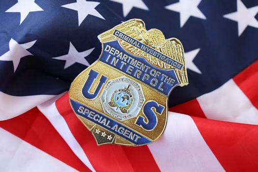 KYIV, UKRAINE - MARCH 9, 2024 US Interpol Special Agent badge on United States of America flag photo