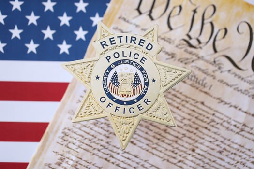 KYIV, UKRAINE - MARCH 9, 2024 US Retired Police Officer badge with United States Constitution on flag photo
