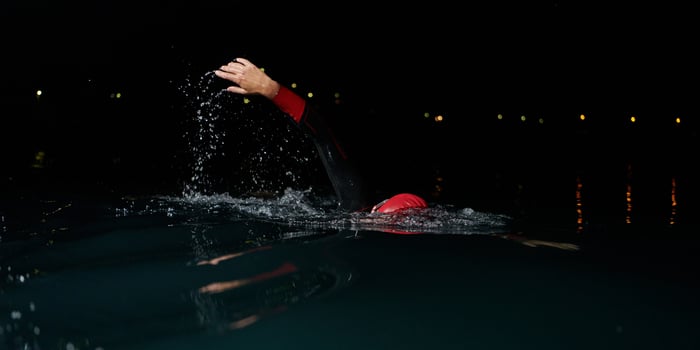 A determined professional triathlete undergoes rigorous night time training in cold waters, showcasing dedication and resilience in preparation for an upcoming triathlon swim competition photo