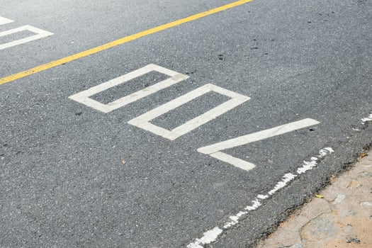 Road surface and yellow traffic lines with numbers seven hundred or 700 on soft sunlight background. photo