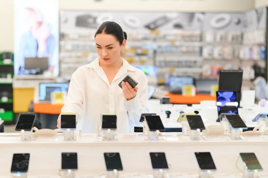 woman chooses new smartphone in store of household appliances, electronics and gadgets photo