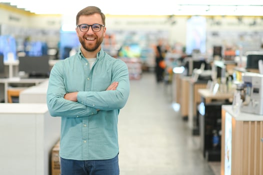 Happy man in electronics store. Big discounts photo