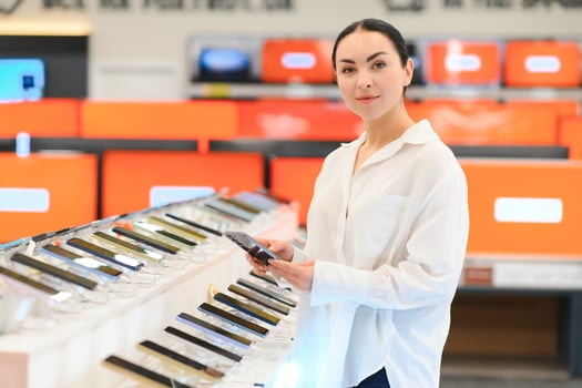 woman chooses new smartphone in store of household appliances, electronics and gadgets photo