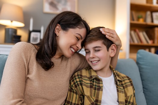 mom and her son have a fun movie night. With popcorn and a laptop, they watch a funny comedy. They laugh together at the jokes and funny scenes, enjoying each other's company. photo
