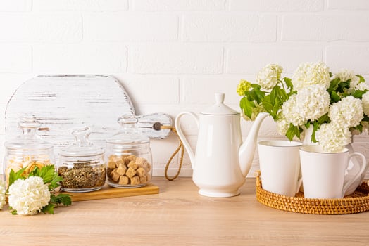 Modern kitchen background in light colors. A set of items for morning coffee on a wooden countertop. A spring flowering branches in a jug. Front view. photo
