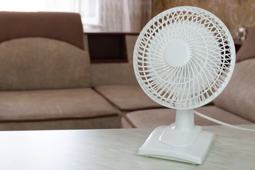 White fan with fast rotating blades for cool air flow in home room photo