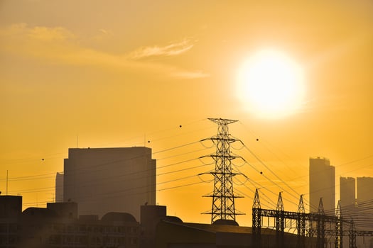 Scorching sun over Bangkok cityscape with modern residential buildings and high voltage electric poles for the concept of gobal warming and greenhouse problems on orange sky background. photo