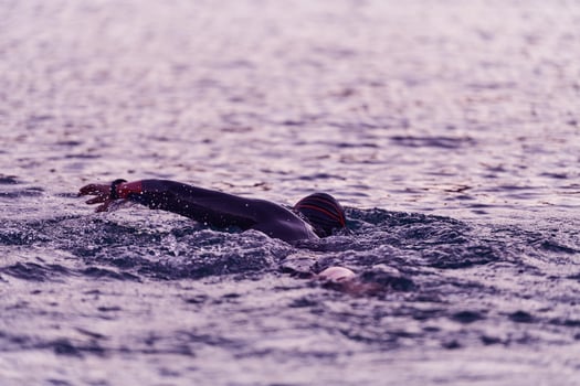 A professional triathlete trains with unwavering dedication for an upcoming competition at a lake, emanating a sense of athleticism and profound commitment to excellence. photo