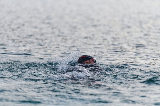 A professional triathlete trains with unwavering dedication for an upcoming competition at a lake, emanating a sense of athleticism and profound commitment to excellence. photo