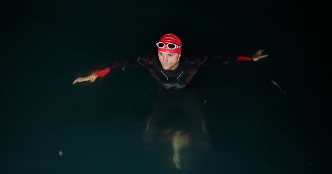A triathlete finds serene rejuvenation in a lake, basking in the tranquility of the water after an intense training session photo