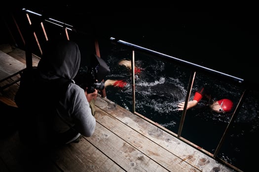 Videographer taking action shot of triathlon swimming athlete at night photo